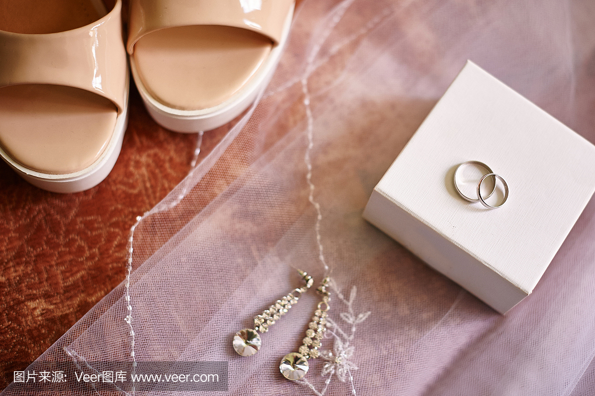 结婚戒指和耳环戴在白色的新娘面纱上